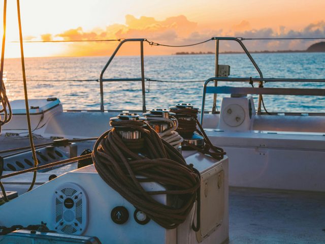 A serene view of a yacht deck during sunset in French Polynesia's Windward Islands.